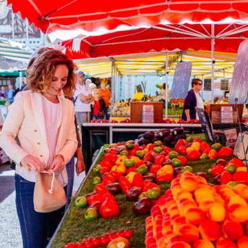 Jeune femme achetant des légumes au Marché