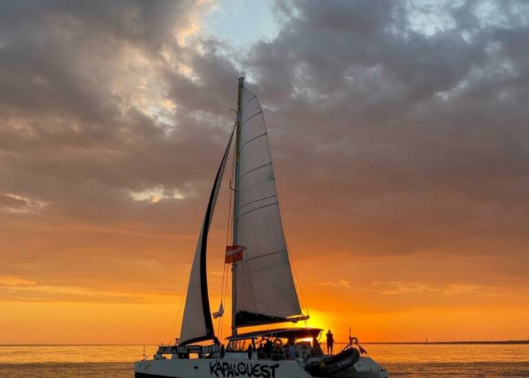 Sailing on a catamaran at sunset - Kapalouest Sailing on a catamaran at sunset - Kapalouest