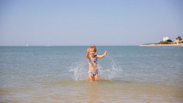 Petite fille jouant dans la mer